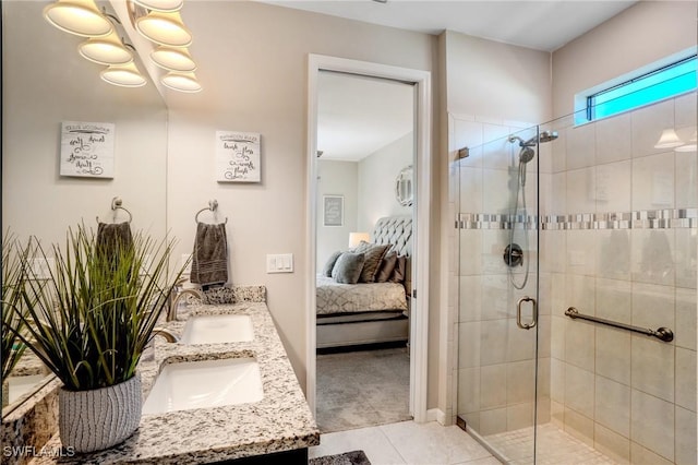 full bathroom featuring double vanity, a shower stall, ensuite bathroom, and a sink