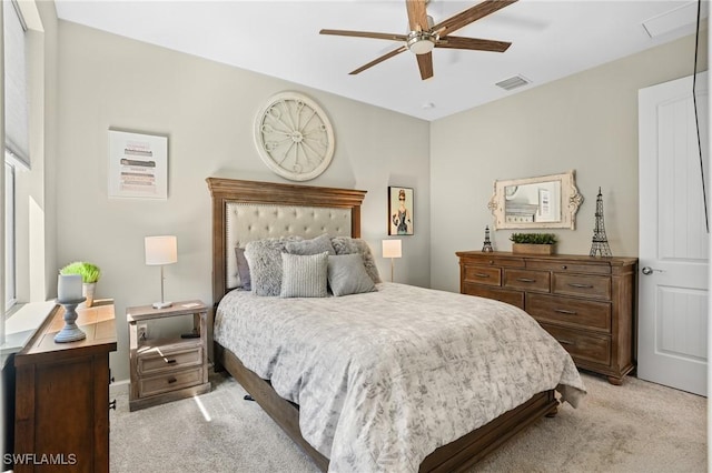 bedroom with visible vents, light colored carpet, and ceiling fan