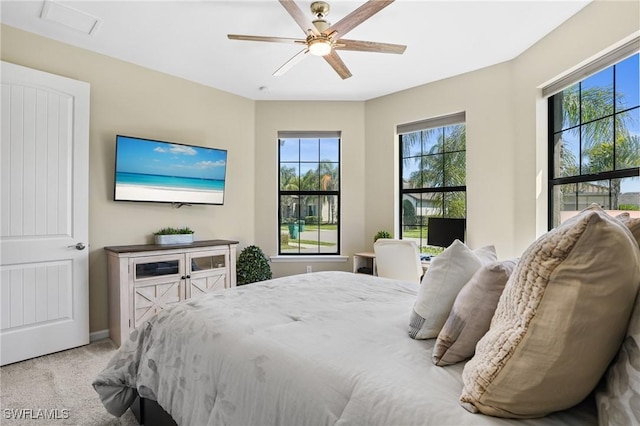 carpeted bedroom featuring multiple windows and ceiling fan