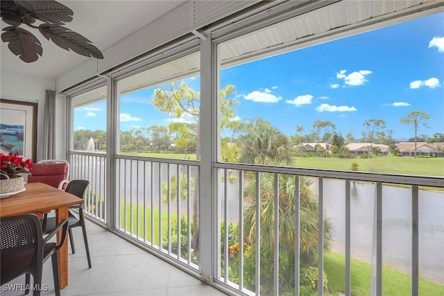 sunroom featuring a water view and ceiling fan