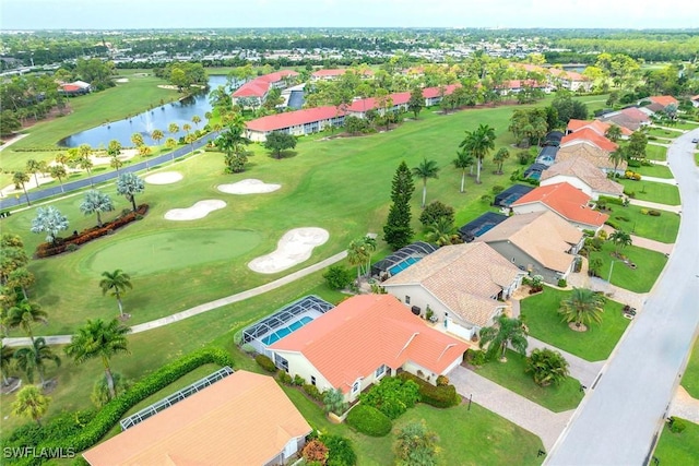 drone / aerial view featuring a water view, view of golf course, and a residential view