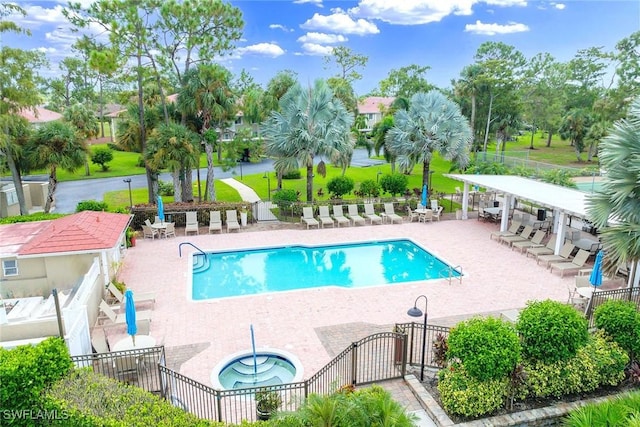 pool featuring a patio, a community hot tub, and fence