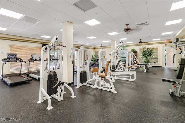 workout area featuring ceiling fan, a drop ceiling, and visible vents