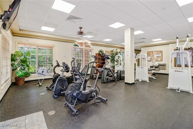 gym with a paneled ceiling, ceiling fan, and visible vents