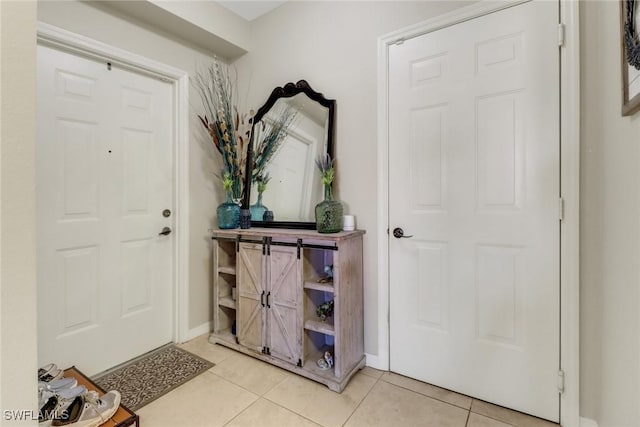 entryway with light tile patterned flooring and baseboards