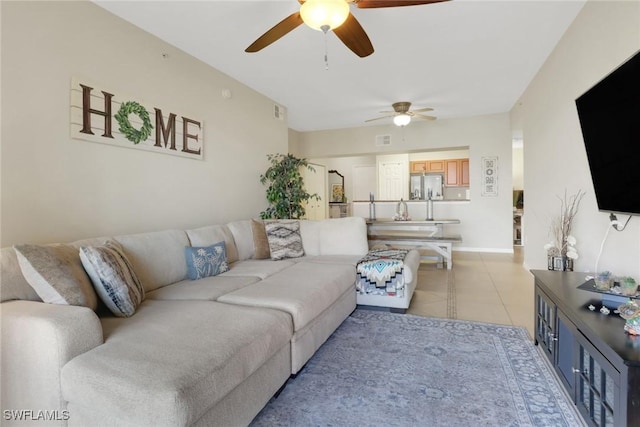 living room featuring light tile patterned floors, visible vents, and a ceiling fan