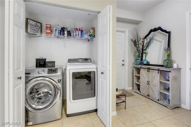 laundry room featuring laundry area, washing machine and dryer, baseboards, and tile patterned floors