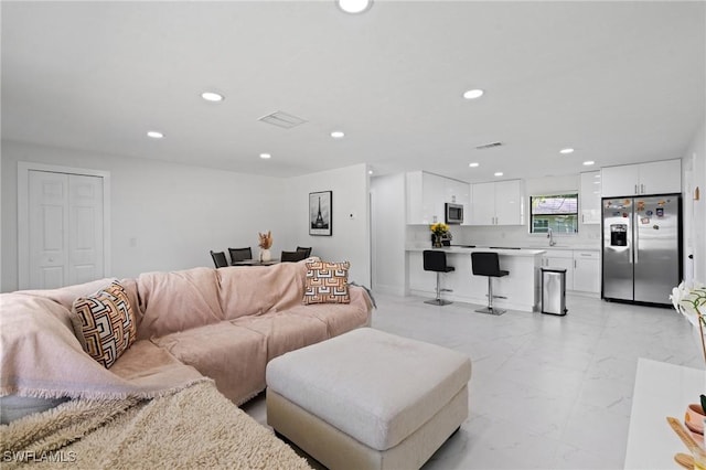 living room featuring recessed lighting, marble finish floor, and visible vents