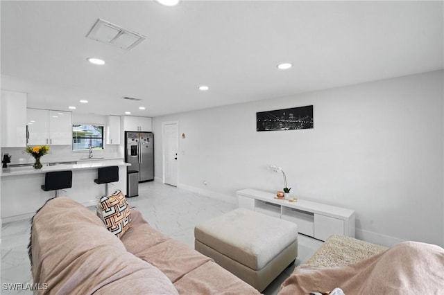 living area with baseboards, marble finish floor, visible vents, and recessed lighting