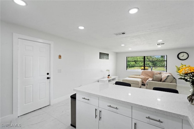 kitchen with recessed lighting, marble finish floor, and visible vents