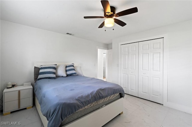 bedroom with marble finish floor, a closet, visible vents, and a ceiling fan