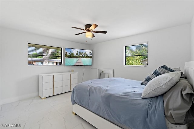 bedroom with marble finish floor, ceiling fan, multiple windows, and baseboards