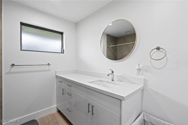 bathroom with baseboards, wood finished floors, and vanity