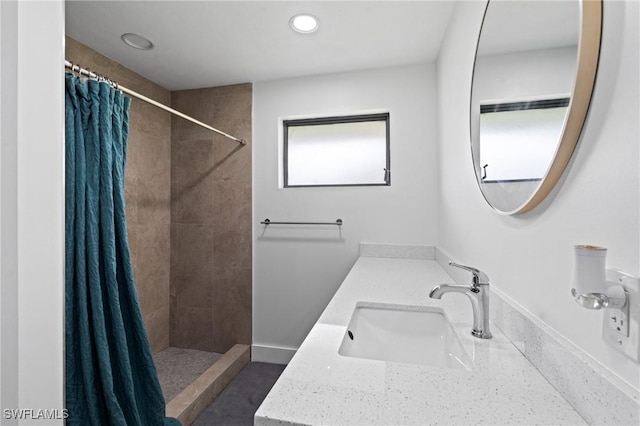 bathroom with recessed lighting, a tile shower, and vanity