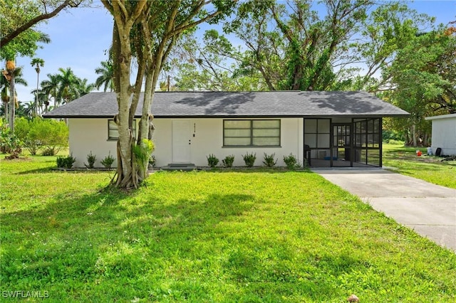 view of front of property with a carport, a front yard, a sunroom, and stucco siding