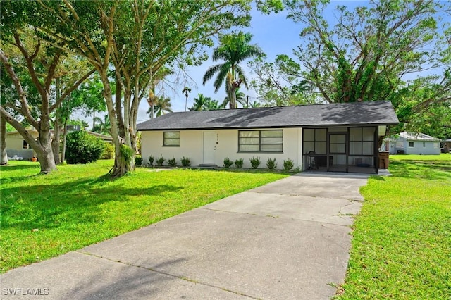 view of front of property featuring driveway, a front yard, and stucco siding