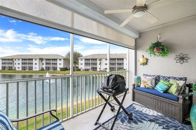 sunroom with a water view and a ceiling fan