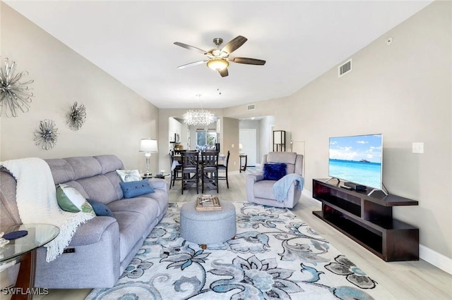 living area featuring baseboards, visible vents, and ceiling fan with notable chandelier