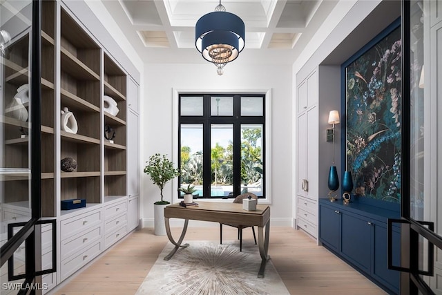 interior space with coffered ceiling, a notable chandelier, beamed ceiling, and light wood finished floors