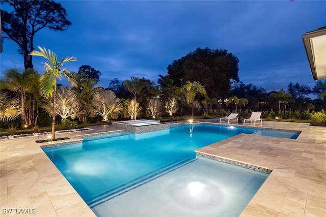 pool with a patio area and an in ground hot tub