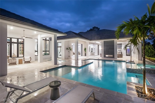 view of swimming pool featuring a ceiling fan, french doors, a patio area, and a pool with connected hot tub