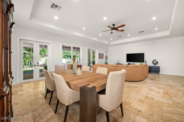 dining space with a tray ceiling, french doors, visible vents, and baseboards