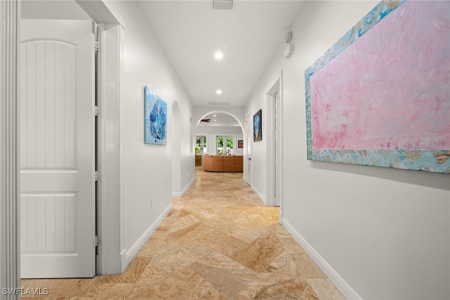 hall with arched walkways, recessed lighting, visible vents, and baseboards