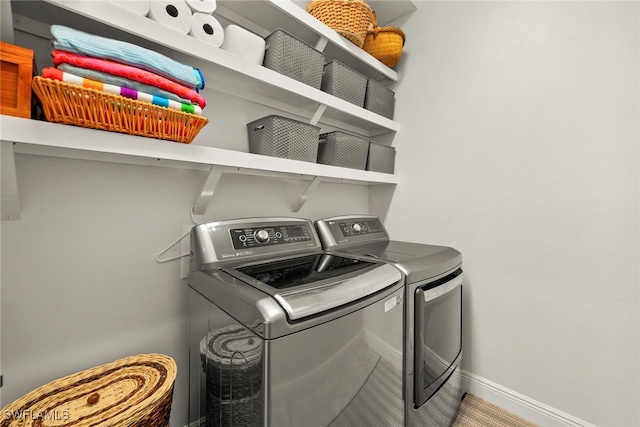 laundry room with laundry area, baseboards, and washer and clothes dryer