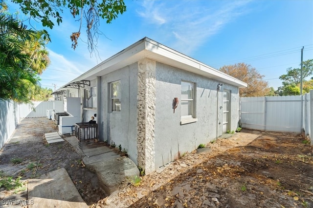 view of side of property featuring a fenced backyard and stucco siding