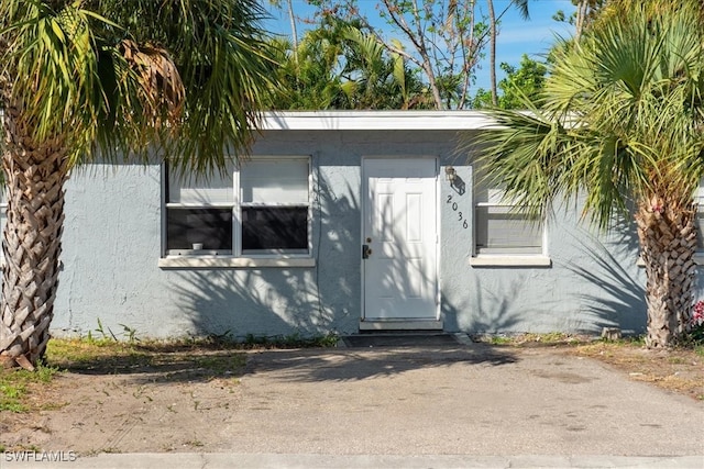 entrance to property featuring stucco siding