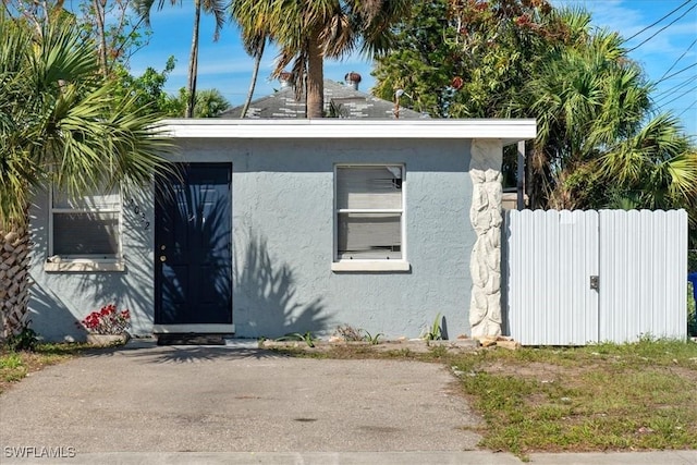 view of front of home featuring a gate, fence, and stucco siding