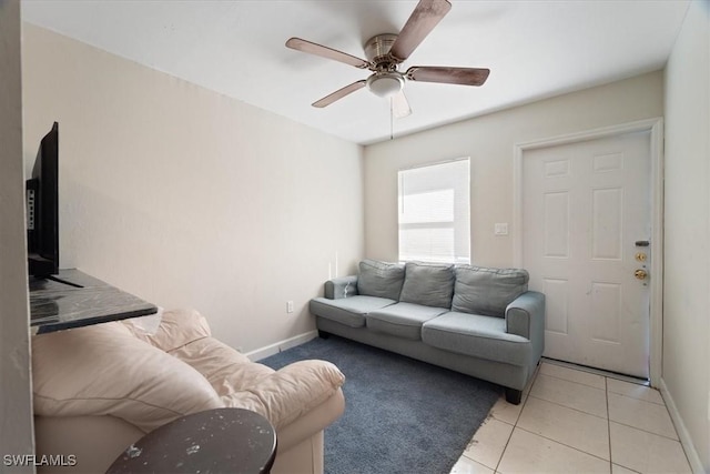 living room featuring light tile patterned floors, baseboards, and a ceiling fan