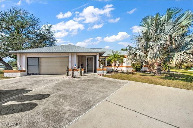 view of front facade with a garage, driveway, and stucco siding