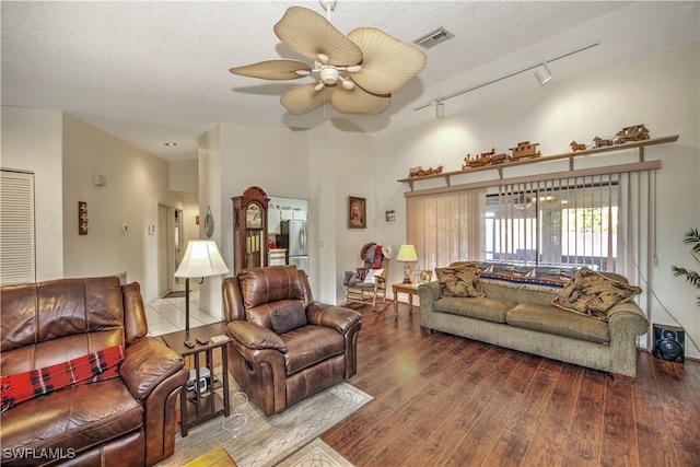 living area featuring ceiling fan, a textured ceiling, wood-type flooring, and visible vents