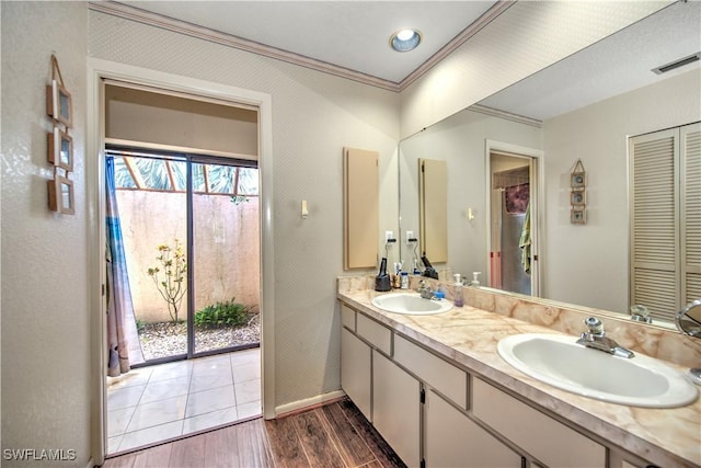 bathroom featuring double vanity, visible vents, a sink, and wood finished floors