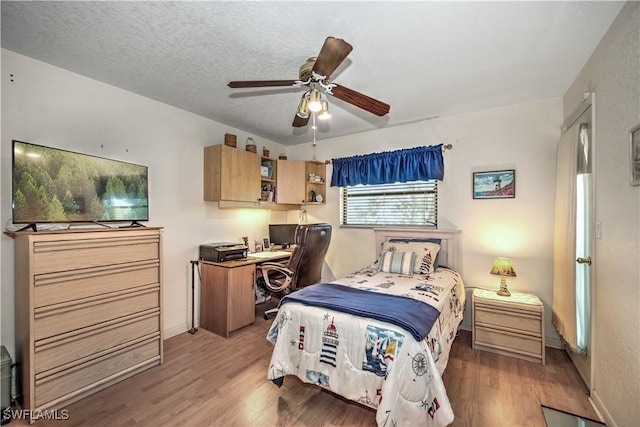 bedroom with a ceiling fan, light wood-style flooring, and a textured ceiling