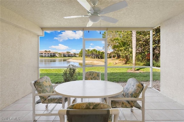 sunroom with a water view and a ceiling fan