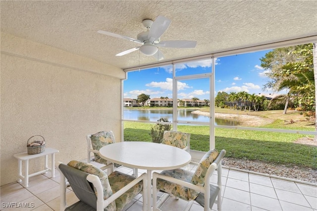 sunroom / solarium with a water view and a ceiling fan