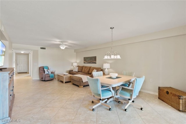 dining room featuring ceiling fan with notable chandelier, light tile patterned flooring, visible vents, and baseboards