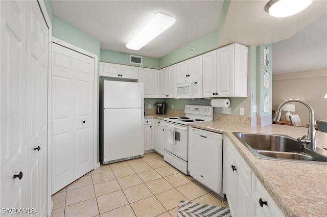 kitchen with white appliances, a sink, visible vents, white cabinets, and light countertops