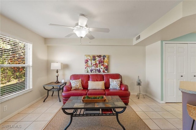 living room featuring light tile patterned floors, baseboards, visible vents, and a ceiling fan