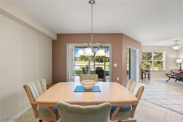 dining area with ceiling fan with notable chandelier, light tile patterned flooring, and baseboards