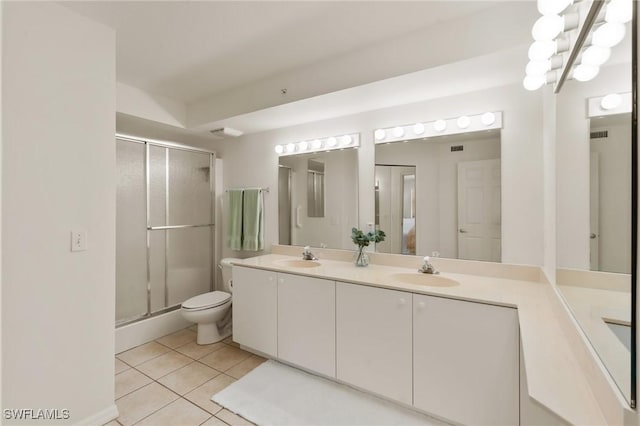 full bathroom with double vanity, a stall shower, tile patterned flooring, and a sink