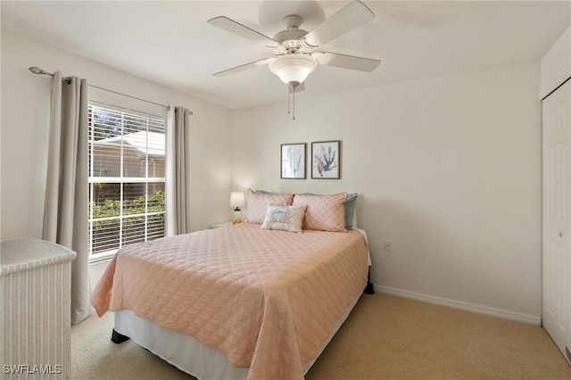 bedroom featuring a ceiling fan, light carpet, and baseboards