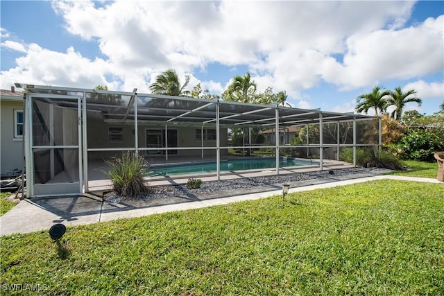 pool with a yard, a patio area, and glass enclosure