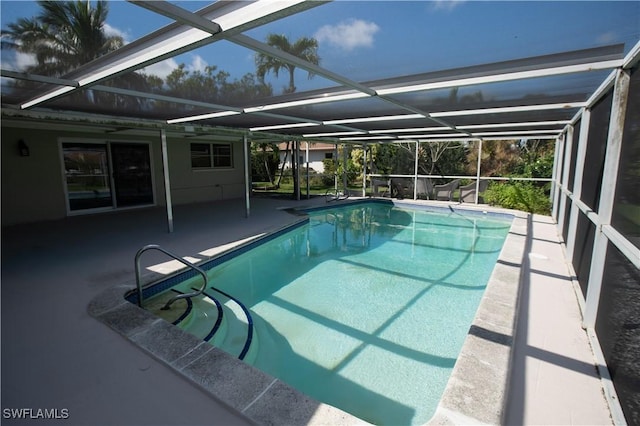 pool with a patio area and glass enclosure