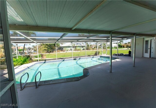 outdoor pool with a patio, a lawn, and a lanai