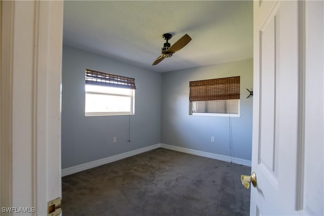 carpeted empty room with ceiling fan and baseboards