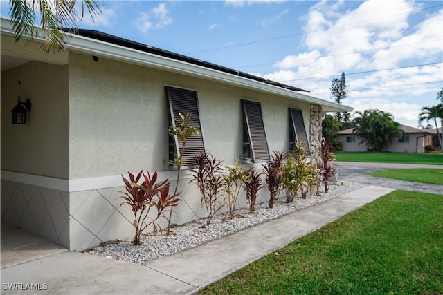 view of side of home featuring a yard and stucco siding