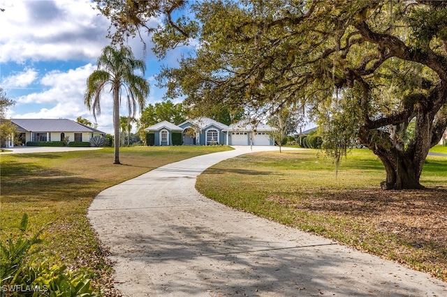 view of front of home with a garage, concrete driveway, and a front yard